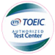 TOEIC Ein rundes Logo mit den Worten „ETS TOEIC Authorized Test Center“. In der Mitte steht das blaue ETS-Logo, daneben der Schriftzug „TOEIC“ in blauer Schrift. Das Design hat einen weißen Hintergrund mit geschwungenen blauen und grünen Farbverläufen am oberen und unteren Rand.